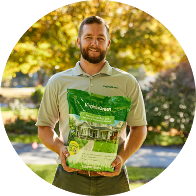 employee holding bag of grass seed